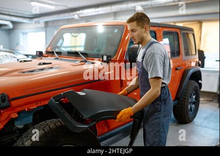 Tecnico che lavora alla messa a punto dell'auto in garage Foto Stock