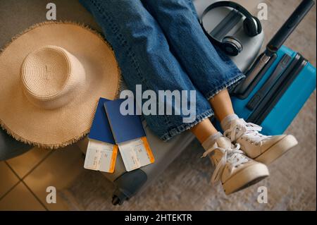 Gamba femminile sulla valigia con biglietti di viaggio Foto Stock