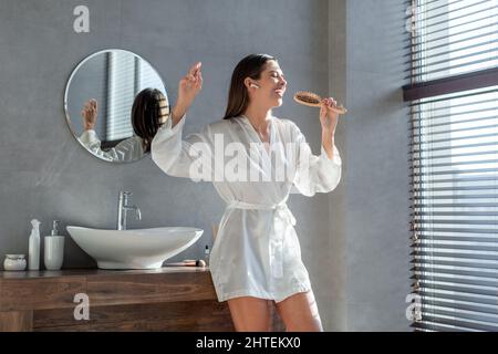 Bella ragazza allegra divertirsi mentre si prepara in bagno Foto Stock