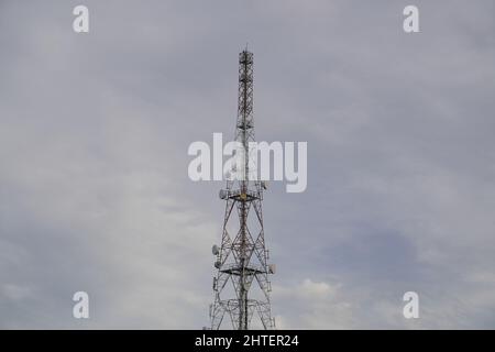 Alto cellulare torre contro un cielo cupo Foto Stock