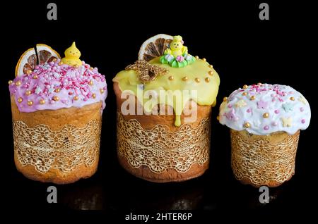 Diverse torte pasquali decorate con glassa su sfondo nero orizzontale. Messa a fuoco selettiva Foto Stock