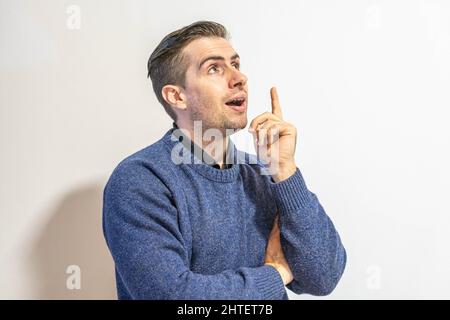 Primo piano dell'uomo in un maglione blu isolato su sfondo bianco. Foto Stock