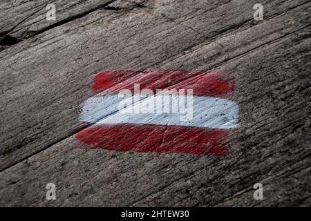 Bandiera austriaca dipinta su una roccia e significa sentiero escursionistico Foto Stock