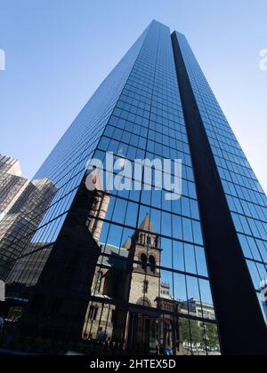 Colpo verticale sul fondo di una torre a specchio John Hancock che riflette altri edifici. Foto Stock