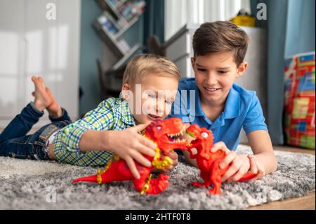 I bambini raccontano storie con dinosauri giocattolo Foto Stock