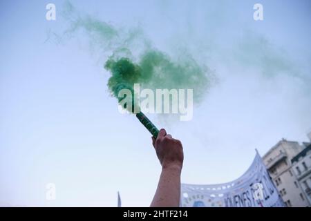 Buenos Aires, Argentina; 24 settembre 2021: Global Climate Strike, Arm raising un fumo verde flare come parte di una performance contro le politiche di lavaggio del verde; Foto Stock