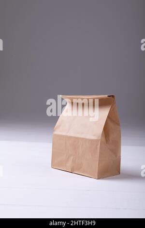 Primo piano della borsa da pranzo di carta marrone sul tavolo su sfondo grigio con spazio per la copia Foto Stock