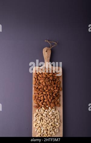 Vista dall'alto di mandorle e casse su tavola di legno su sfondo grigio con spazio per la copia Foto Stock