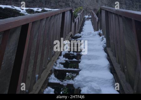 Scale ad angolo basso foto, inverno e neve a gradino e scale, recinzioni in legno di passo all'aperto nella cascata di Palovit Foto Stock