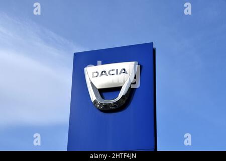 Pontypridd, Galles - Febbraio 2022: Segno fuori di uno showroom di Dacia auto isolato contro un cielo blu. Nessuna gente. Foto Stock