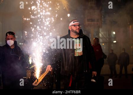 Uno sparatutto professionale a razzo che fa una dimostrazione di fuochi d'artificio prima dell'inizio della Corda all'interno del Cohetodromo in Plaza del Ayuntamiento a Valencia. La Corda de Paterna, è una dimostrazione pirotecnica notturna con più di 200 anni di antichità che si celebra durante le maggiori festività di questa città, che consiste di razzi brucianti all'interno di uno spazio abilitato, il Cohetodromo. I partecipanti, che si vestono in abiti speciali per evitare ustioni, stanno catturando e lanciando razzi e fuochi d'artificio all'interno dell'area chiusa. Dopo due anni senza insuccessi ufficiali dovuti alla pandemia in situ Foto Stock