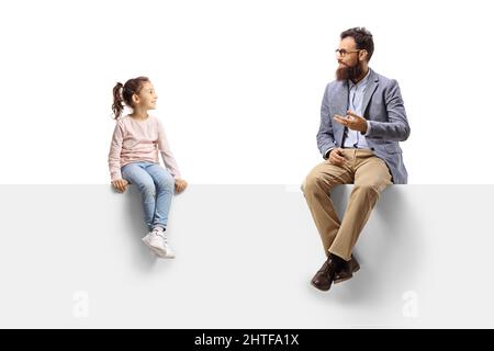 Uomo seduto su un pannello vuoto gesturando con mano e parlando con una bambina isolato su sfondo bianco Foto Stock