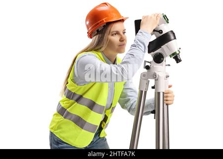 Ingegnere geodetico femminile che misura con una stazione di posizionamento isolata su sfondo bianco Foto Stock