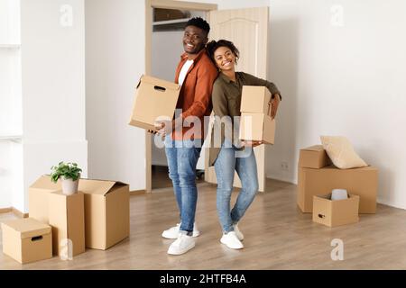 Joyful Black Couple Holding scatole in movimento nella loro nuova Casa Foto Stock