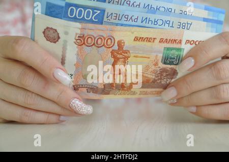 Le mani femminili tengono i rubli russi in contanti. 2000, 5000 ruble banconote primo piano. Foto Stock