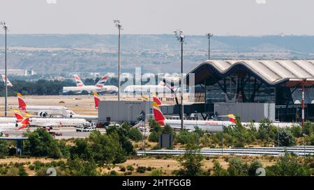 Vista ingrandita lunga degli aeroplani su asfalto e l'iconico tetto dell'Aeroporto di Bajaras a Madrid, Spagna Foto Stock