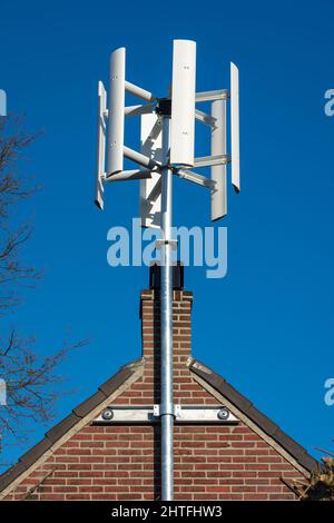 Piccola turbina eolica ad asse verticale per abitazioni, primo piano di un piccolo generatore di energia montato sulla facciata della casa Foto Stock