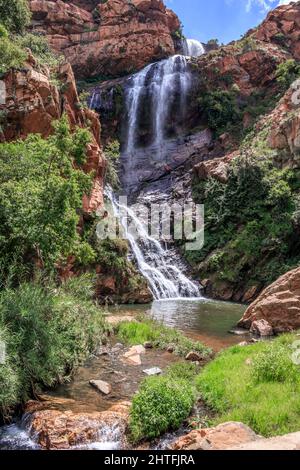 Vista di una cascata e di un fiume in un'area montagnosa nei giardini botanici nazionali di Walter Sisulu, Johannesburg, Sudafrica Foto Stock