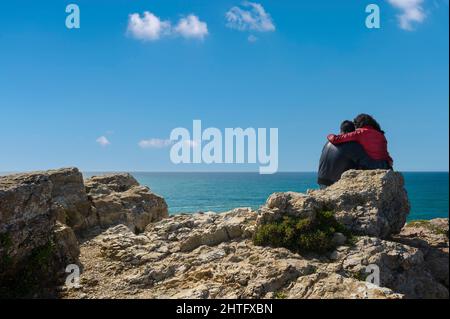 Costa ripida a Cabo de Sao Vicente con una giovane coppia, Sagres, Algarve, Portogallo, Europa Foto Stock