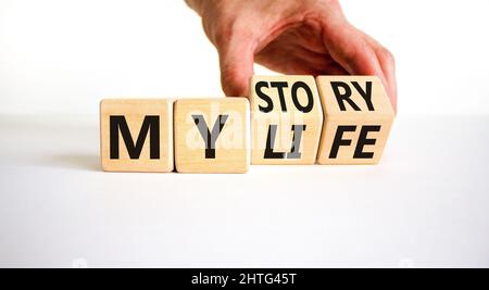 Storia della mia vita simbolo. Businessman trasforma i cubi di legno e cambia le parole di concetto la mia storia alla mia vita. Bella tabella bianca sfondo bianco. Autobus Foto Stock