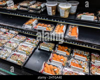 Kirkland, WA USA - circa Febbraio 2022: La vista ad angolo del sushi preconfezionato varia all'interno di una sezione di cibo preparato del mercato di cibi interi. Foto Stock