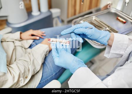 Primo piano del modello dentistico femminile che tiene i denti spiegando al paziente l'igiene orale e la cura delle gengive Foto Stock