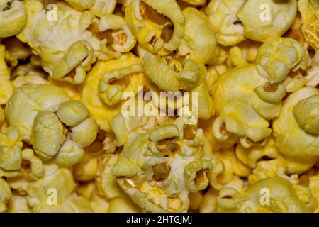 Chicchi di popcorn insaporiti con formaggio giallo da vicino con dettagli e texture direttamente dall'alto, fuoco selettivo. Foto Stock