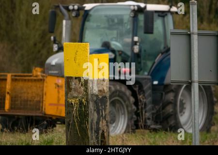 Trattore FENDT 720 dotato di una scatola di trasporto con attacco rapido Twose gialla, che procede lungo una corsia di campagna Foto Stock