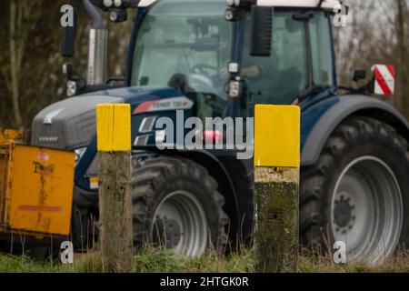 Trattore FENDT 720 dotato di una scatola di trasporto con attacco rapido Twose gialla, che procede lungo una corsia di campagna Foto Stock