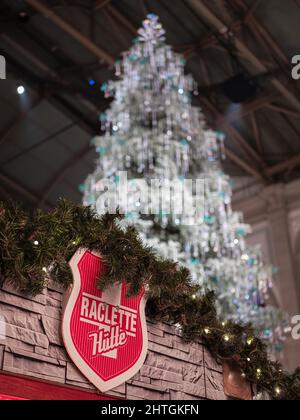 Zurigo, Svizzera - 30 novembre 2021: Uno stand di vendita di raclette sotto un albero di Natale Swarovski tradizionale alla stazione ferroviaria di Zurigo Foto Stock