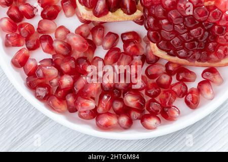 Semi di melograno sul piatto Foto Stock