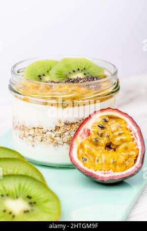 Durante la notte avena con frutta fresca della passione, kiwi e semi di chia nel vaso di vetro, fotografia alimentare Foto Stock