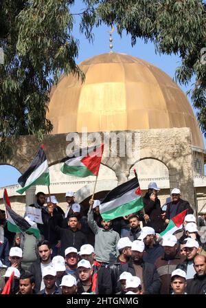 Khan Younis, Gaza. 28th Feb 2022. I palestinesi ondano bandiere nazionali durante un raduno di fronte ad una replica della cupola della roccia della moschea di al-Aqsa, a Khan Younis, nella striscia meridionale di Gaza, lunedì 28 febbraio 2022, Per protestare contro una dichiarazione del primo ministro francese Jean Castex secondo cui Gerusalemme è 'la capitale eterna del popolo ebraico' durante un evento a Parigi del Consiglio dei rappresentanti delle istituzioni ebraiche francesi. Foto di Ismael Mohamad/UPI Credit: UPI/Alamy Live News Foto Stock