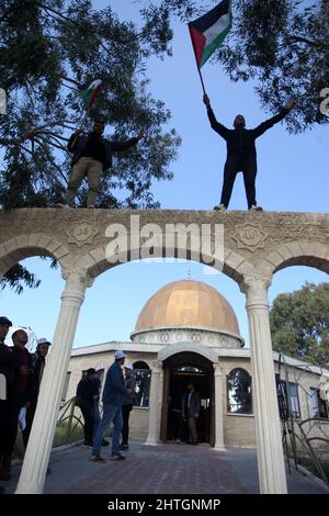 Khan Younis, Gaza. 28th Feb 2022. I palestinesi ondano bandiere nazionali durante un raduno di fronte ad una replica della cupola della roccia della moschea di al-Aqsa, a Khan Younis, nella striscia meridionale di Gaza, lunedì 28 febbraio 2022, Per protestare contro una dichiarazione del primo ministro francese Jean Castex secondo cui Gerusalemme è 'la capitale eterna del popolo ebraico' durante un evento a Parigi del Consiglio dei rappresentanti delle istituzioni ebraiche francesi. Foto di Ismael Mohamad/UPI Credit: UPI/Alamy Live News Foto Stock