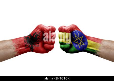 Due mani si pugno l'una all'altra su sfondo bianco. Bandiere di paese dipinte pugni, conflitto concetto di crisi tra albania ed etiopia Foto Stock
