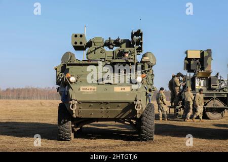 Orzysz, Polonia. 24 Febbraio, 2022. Soldati dell'esercito degli Stati Uniti, assegnati a 5th battaglione, 4th reggimento dell'artiglieria di difesa dell'aria, dirigono un sistema di SHORAD di Stryker A1 all'area di addestramento di Bemowo Piskie, 24 febbraio 2022 fuori di Orzysz, Polonia. Gli Stati Uniti hanno aumentato le forze NATO nella regione per contrastare la minaccia della Russia contro l'Ucraina. Credito: SSgt. Clinton Thompson/United States Army/Alamy Live News Foto Stock