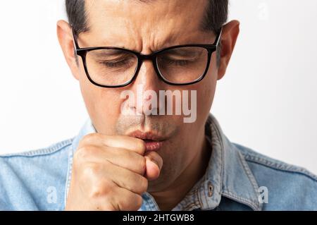 Uomo che indossa gli occhiali su sfondo isolato sensazione di malessere e tosse come sintomo per il freddo o bronchite. Concetto di assistenza sanitaria. Foto Stock