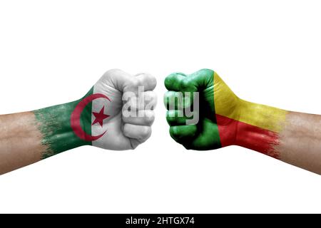 Due mani si pugno l'una all'altra su sfondo bianco. Bandiere di paese dipinte pugni, conflitto concetto di crisi tra algeria e benin Foto Stock