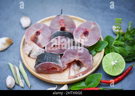 Pesce Snakehead per la cottura del cibo, pesce a strisce con testa di serpente tritato con ingredienti limone su piatto di legno e tavola fondo cucina, fresco crudo Snake h Foto Stock