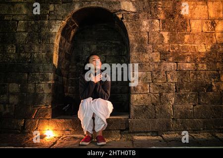 Kathmandu, Nepal. 28th Feb 2022. Una ragazza osserva i rituali religiosi alla vigilia del festival Maha Shivaratri presso i locali del tempio di Pashupatinath. Credit: SOPA Images Limited/Alamy Live News Foto Stock