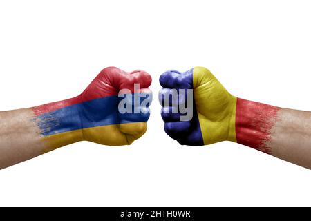 Due mani si pugno l'una all'altra su sfondo bianco. Bandiere di paese dipinte pugni, conflitto di crisi concetto tra armenia e romania Foto Stock