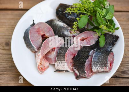 Pesce testa di serpente per cucinare cibo, pesce testa di serpente a strisce tritato con ingredienti foglia di basilico santo su piatto bianco e tavola di legno fondo cucina, F Foto Stock