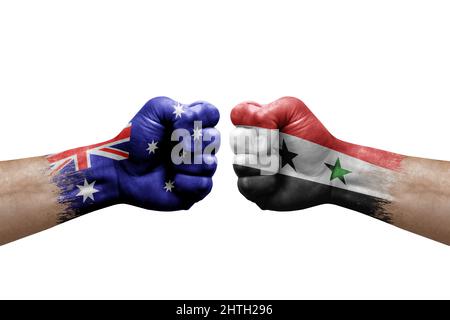 Due mani si pugno l'una all'altra su sfondo bianco. Le bandiere di paese dipinse i pugni, concetto di crisi di conflitto tra australia e siria Foto Stock