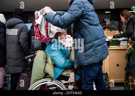 Przemysl, Polonia. 28th Feb 2022. Un uomo copre con una coperta un anziano disabili ucraino lady.on il quinto giorno dell'invasione russa sull'Ucraina, migliaia di richiedenti asilo arrivano in treno a Przemy?l. La capacità di ogni treno è stimata in duemila persone. Credit: SOPA Images Limited/Alamy Live News Foto Stock