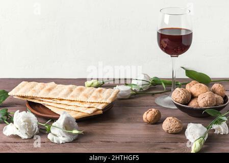 Festa di Pesah (Pasqua ebraica), spazio di copia. Pane tradizionale matza, noci, vino e fiori primaverili su tavola di legno. Happy Pass Foto Stock