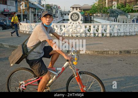 Un ciclista che passa sopra il ponte Charoenrat 31, un ponte klong (canale) a Bangkok, Thailandia Foto Stock