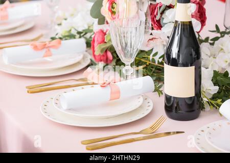 Elegante ambiente da tavolo con inviti per matrimoni e bottiglia di champagne Foto Stock