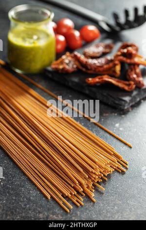 Spaghetti interi non cotti. Pasta cruda su un tavolo da cucina. Foto Stock