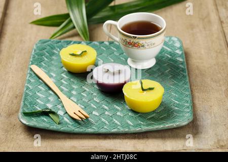 Talam Cake o in Indonesia chiamato Kue Talam Ubi Jagung con foglie di Pandan sulla parte superiore, serve su piastra in ceramica Foto Stock