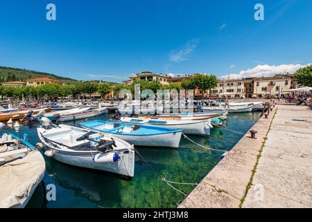 Piccolo porto del Lago di Garda. Numerose barche ormeggiate, e paesaggio urbano del Garda, famosa località turistica in provincia di Verona, Veneto, Italia, Europa meridionale. Foto Stock
